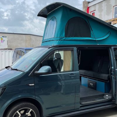Turquoise vw camper van with custom pop top